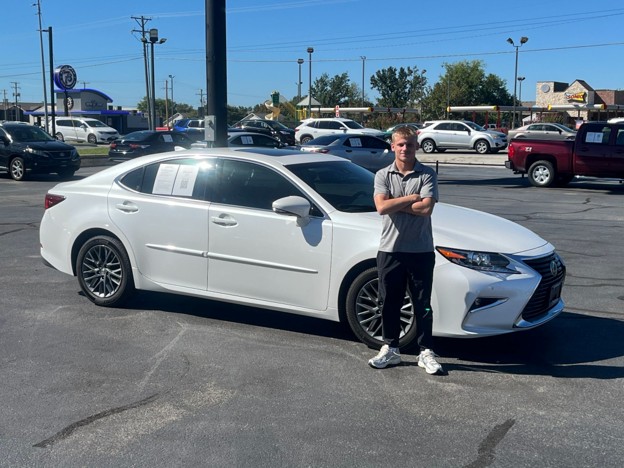 Joplin Blog – Used Sedans Buyer checking the tires on a four-door car while shopping for used sedans Joplin MO